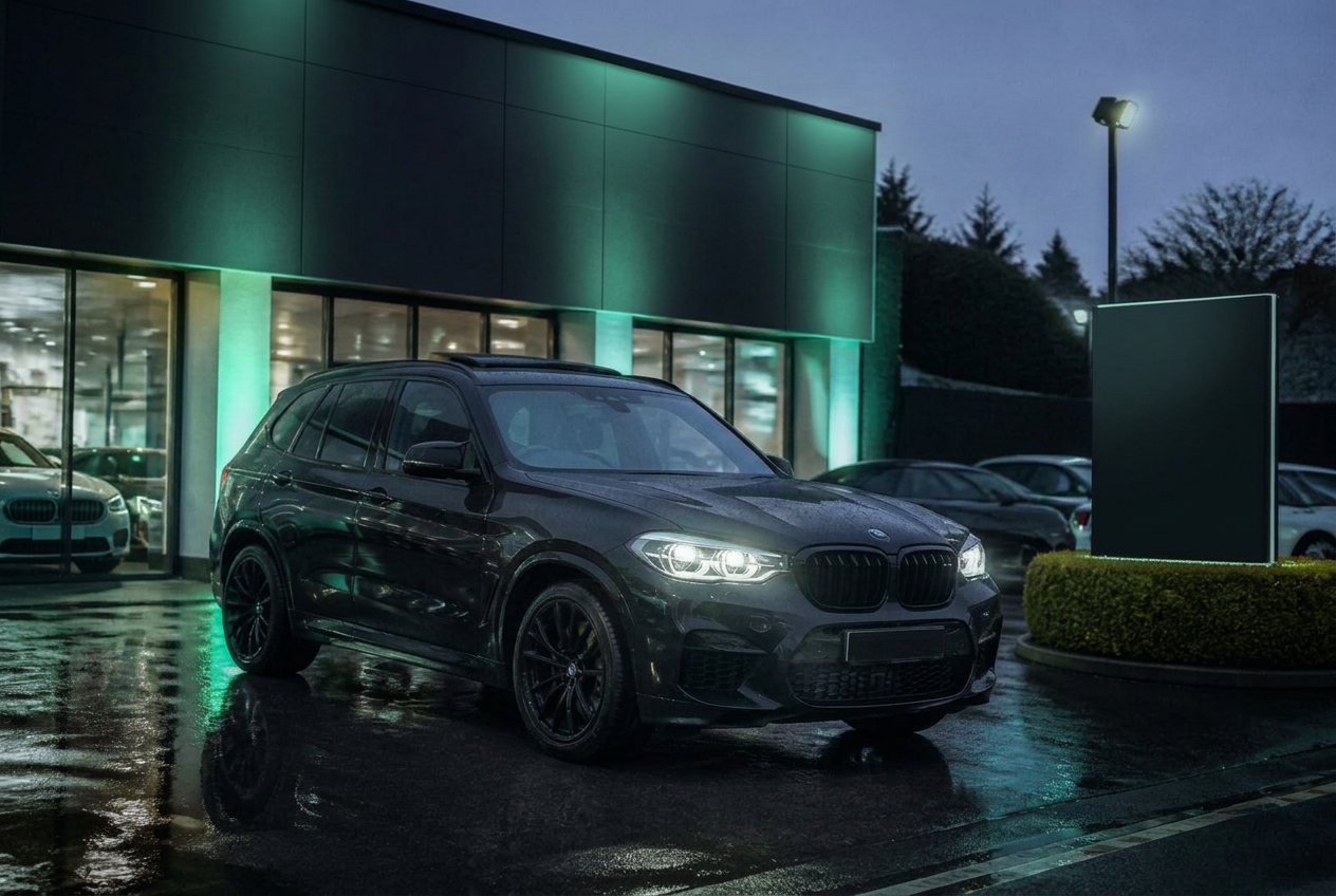 Mint Cars forecourt at dusk with a BMW under mint-green ambient light